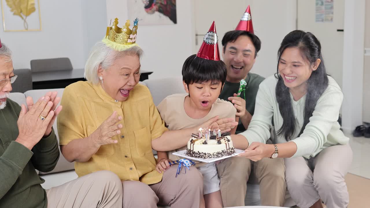 A family gathers around a birthday cake, sharing smiles and laughter in a warmly lit living room