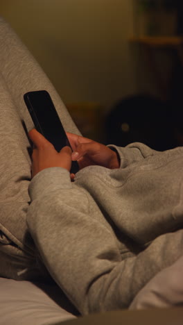 person using a smartphone in bed at night