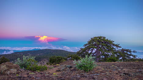 las nubes épicas cambian de color con luz amarilla roja dorada a tonos rosados azules desde la cima de la montaña