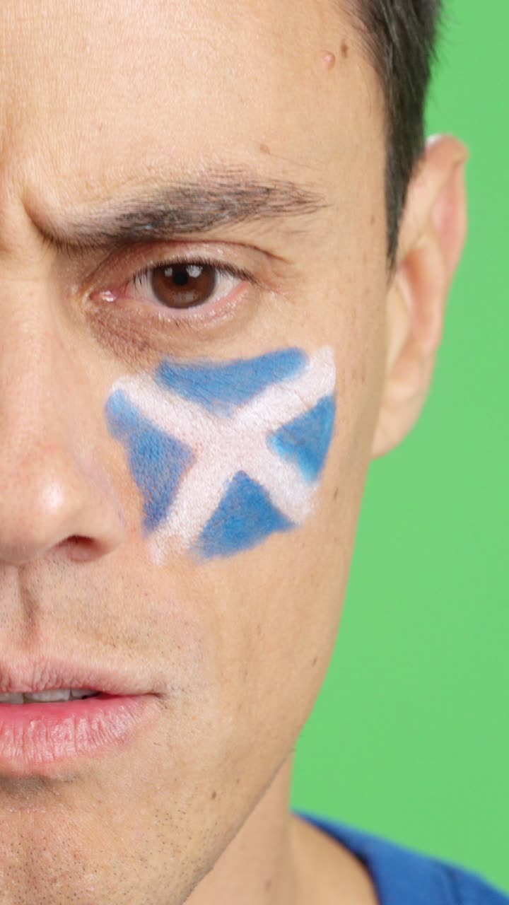 Serious man with a scottish flag painted on the face