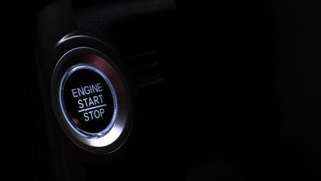 the driver's hand is pressing the car start button. concept of transportation and technology