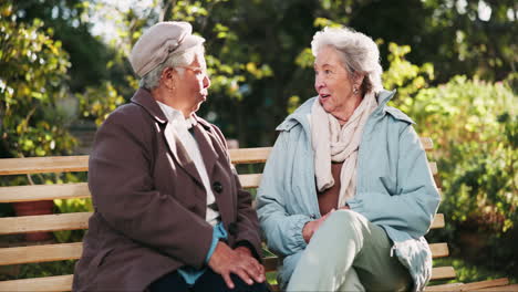 two elderly women enjoying a conversation on a park bench