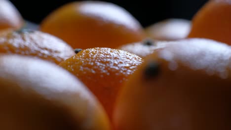 pile of unpeeled round ripe orange mandarin in a plate