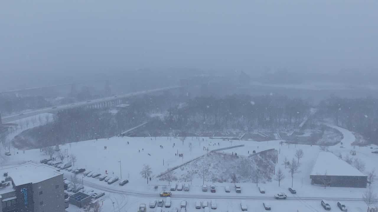 Aerial footage rotating around Renaissance Park and the people sledding on the hills during a snowstorm in Chattanooga, TN.