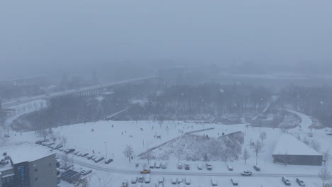 aerial footage rotating around renaissance park and the people sledding on the hills during a snowstorm in chattanooga, tn.