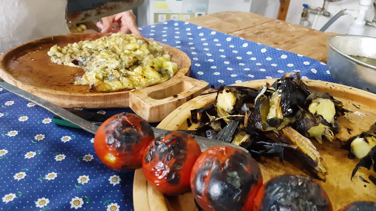 hacha cortar parrilla berenjena en plato de madera barbacoa tomate quemar piel píldora de verduras comida vegana cocina persa de la gente de irán en la provincia de gilan irán mezclar envolver sabroso ajo maravilloso paisaje local