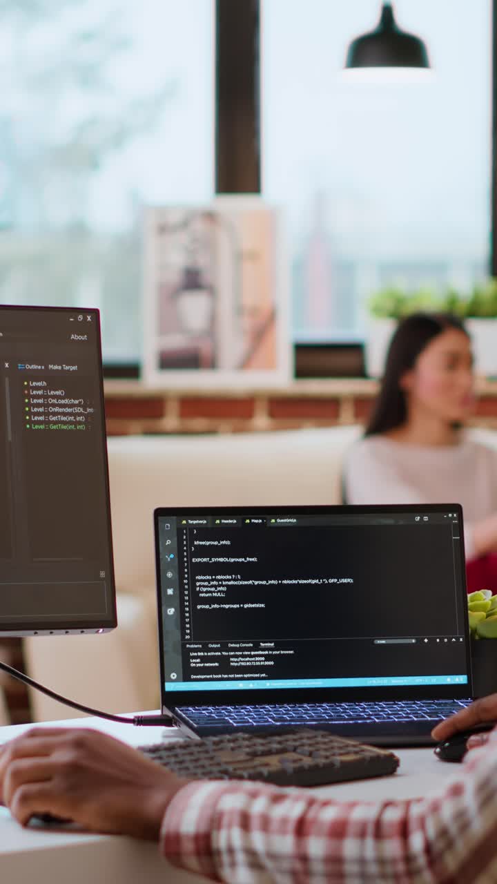 Vertical Video Male coder works from home typing code on a laptop in a modern living room