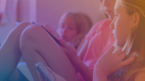 spots of light against three caucasian sisters using smartphone at home