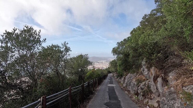 Vista lungo una strada che scende dalla Rocca di Gibilterra. Panorami della città e della baia sullo sfondo.