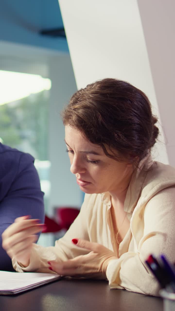 Donna professionista che discute documenti in una riunione d'ufficio