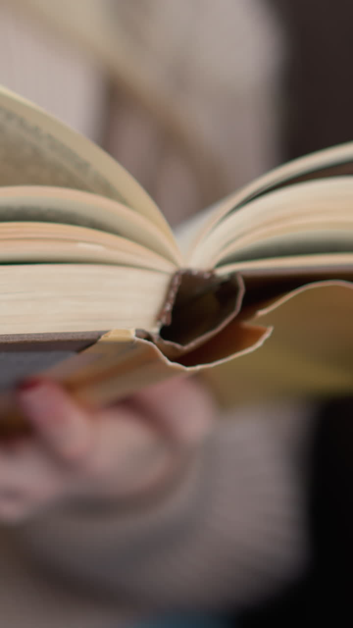 primer plano de una mano volviendo suavemente una página de un libro, mostrando el proceso de giro de la página, con las páginas abiertas del libro y el movimiento de los dedos capturado contra un fondo suave