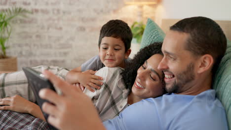 Family,-bed-and-watching-on-tablet-with-a-smile