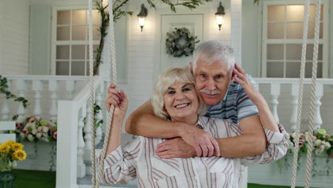 Pareja-De-Ancianos-Juntos-En-El-Patio-Delantero-De-Casa.-Hombre-Balanceándose-Y-Abrazando-A-Una-Mujer.-Familia-Madura-Feliz