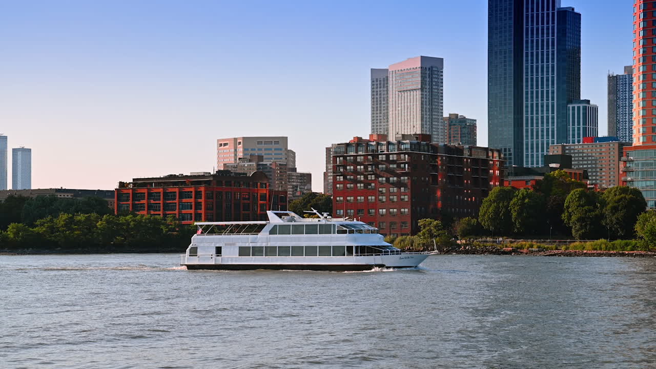 Boat cruising city riverfront. A sleek boat travels smoothly on the river, surrounded by vibrant city buildings during a clear day