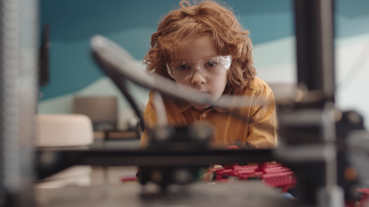 Red-haired Boy Watching Machine Working in Classroom