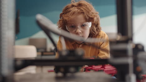 red-haired boy watching machine working in classroom
