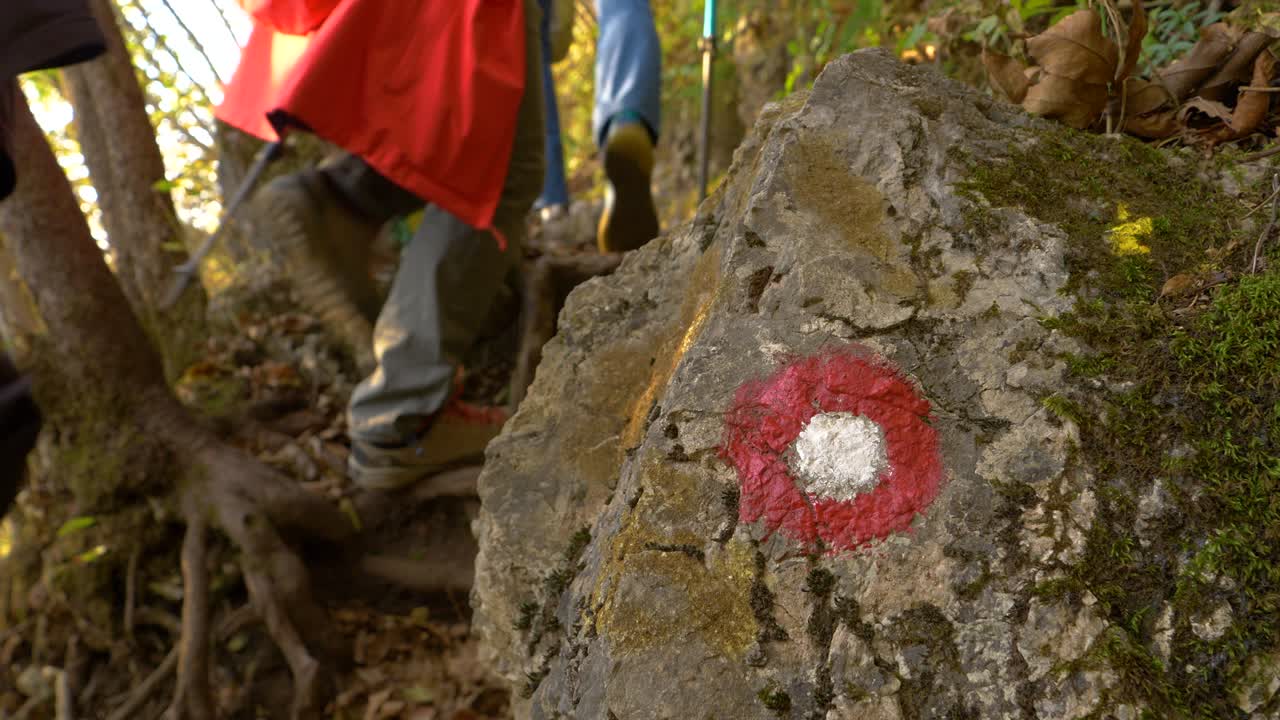 de cerca: los círculos rojos y blancos muestran el camino a los excursionistas irreconocibles que caminan cuesta arriba