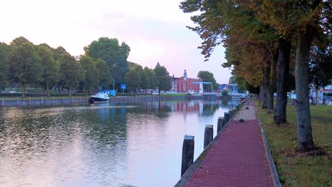 Slow-dolly-zoom-on-canal-quay-of-dutch-delta-river-the-maas-in-den-bosch-sunset