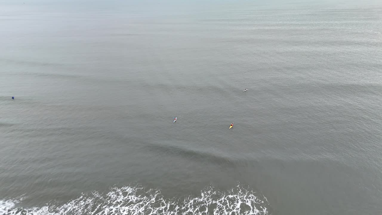 Aerial drone view surfers surfing kayaks kaykaing tynemouth north east england uk north sea