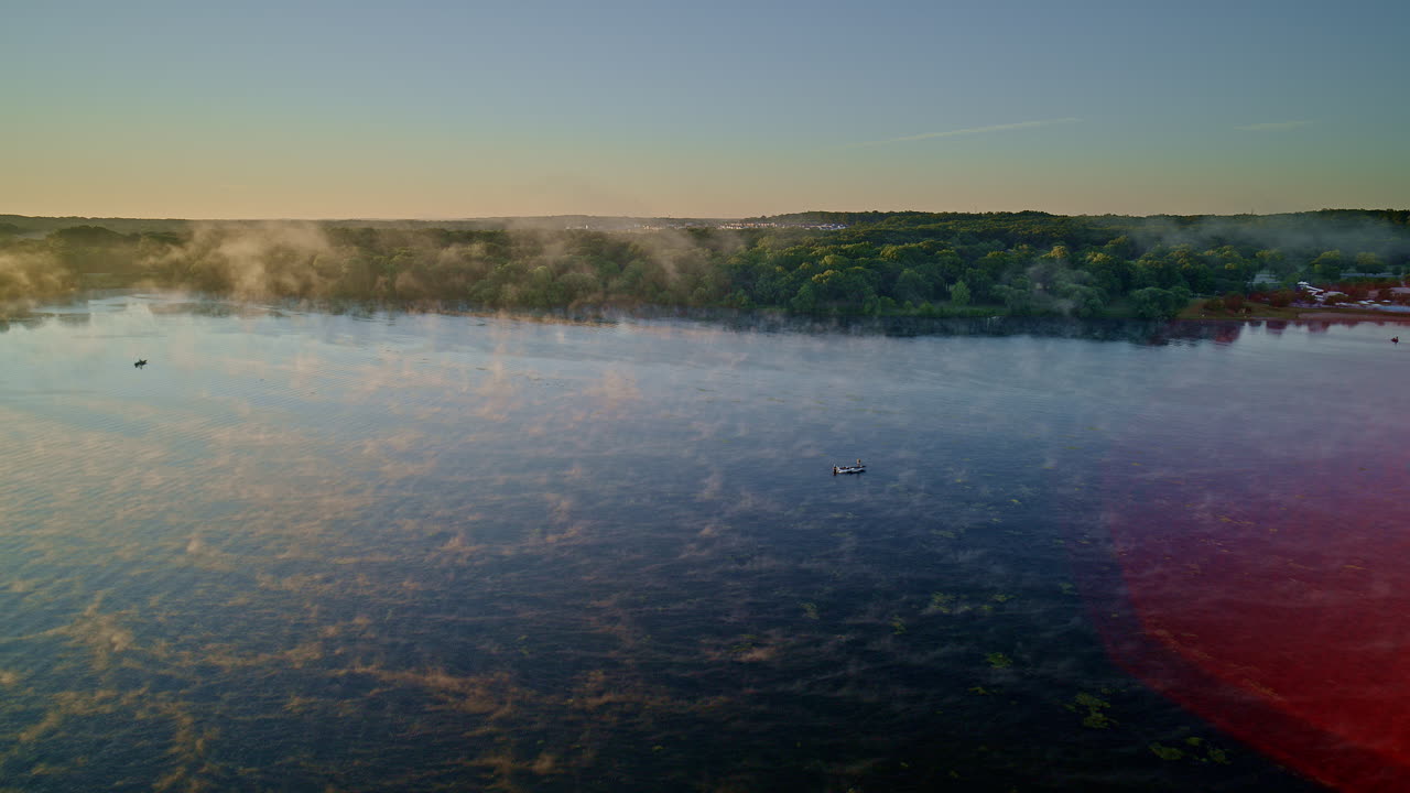 Sunrise over a Misty Lake with Fishermen