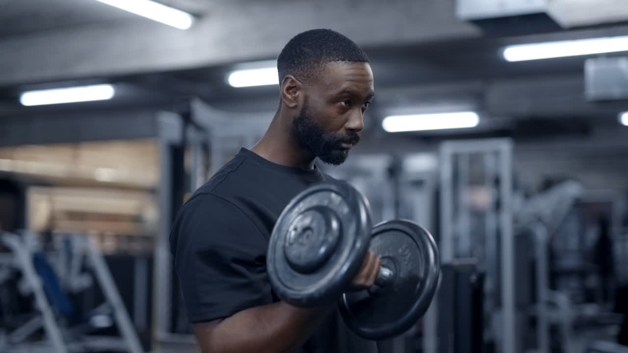 Athletic black man doing bicep dumbbell curls