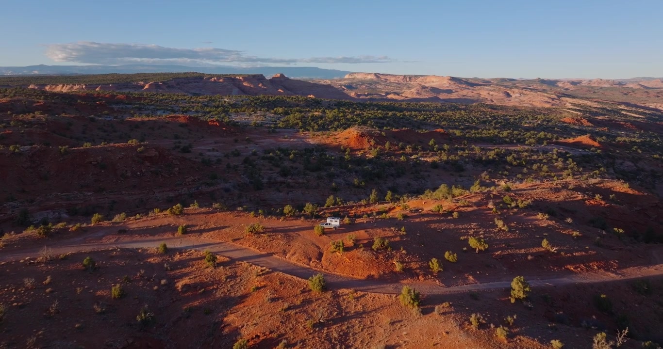 Rode woestijnruggen en met jeneverbessen begroeide heuvels in Grand Staircase Escalante Utah, drone dolly boven truck camper