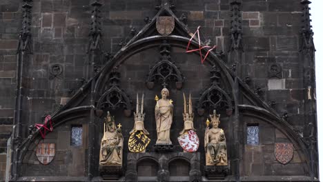 detalle de las estatuas y escudos de armas en la torre del puente de la vieja ciudad en praga, república checa