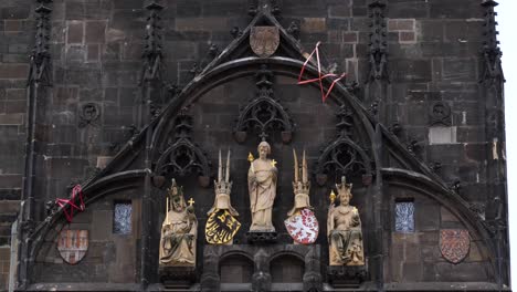 detail of the statues and coats of arms on the old town bridge tower in prague, czech republic