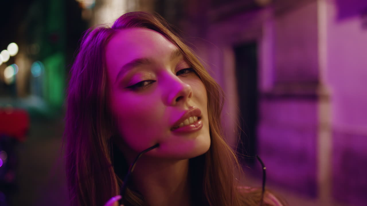 chica de moda de primer plano posando en la ciudad de la noche con gafas de sol. mujer en la ciudad nocturna