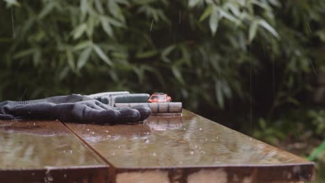 Raindrops-Falling-On-The-Surface-With-Rubber-Glove-And-Toy-Car-Outdoor---close-up