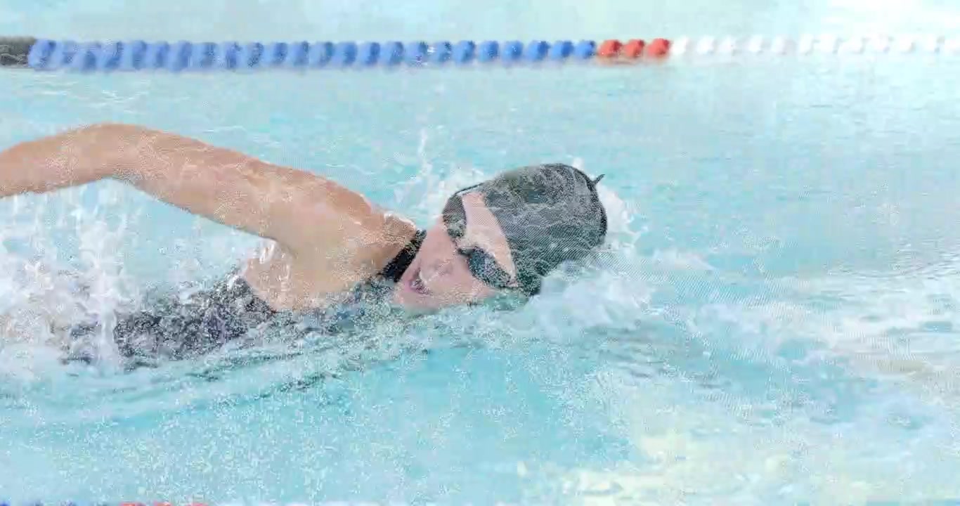 Female swimmer performing crawl stroke in lap pool for training with animated speed graph overlay
