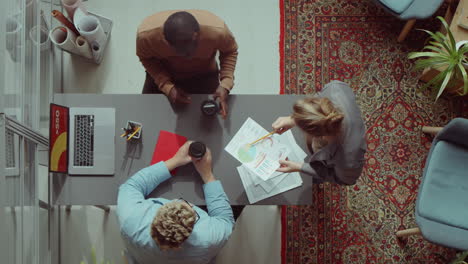 diverse coworkers discussing business papers in office