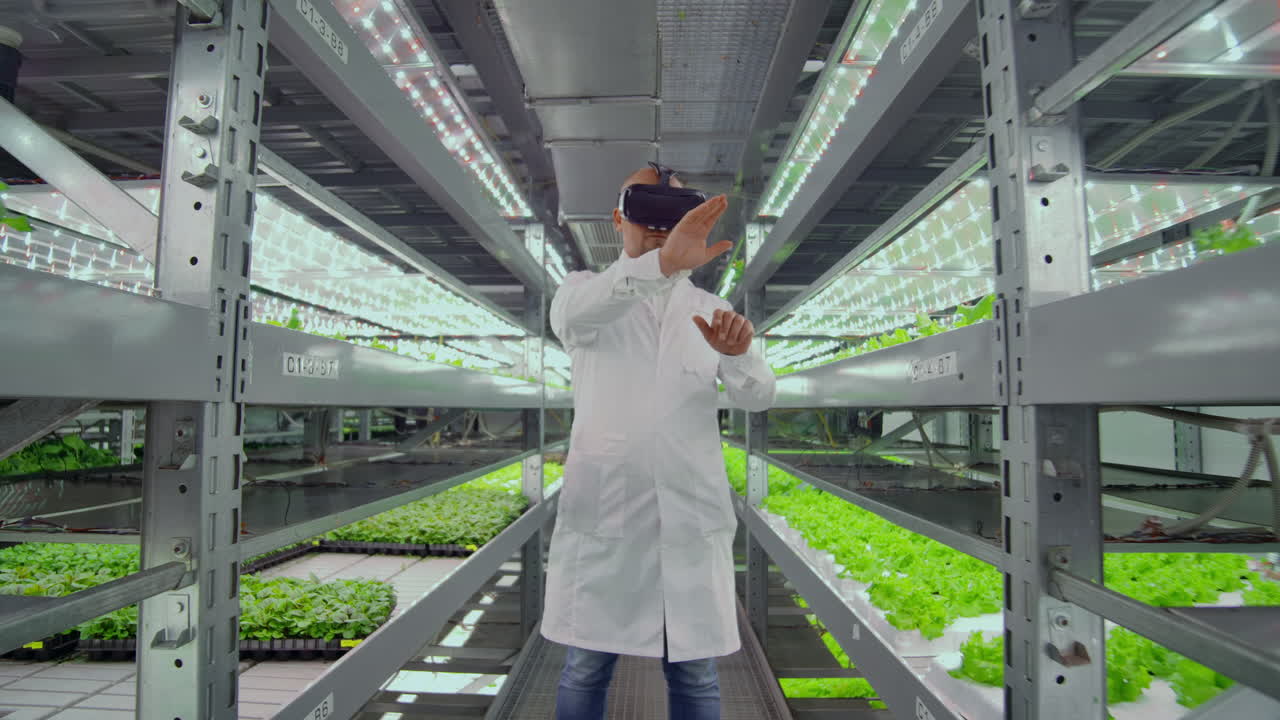 los científicos un hombre con una bata blanca de laboratorio usan gafas de realidad virtual en la granja con la hidroponía para el control del riego. los genetistas analizan la composición de las verduras que crecen en las plantaciones
