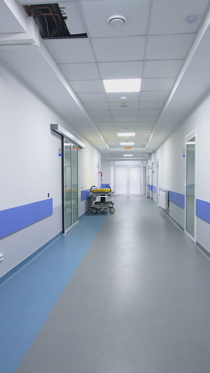 Corredor vazio no hospital. Longo corredor hospitalar iluminado com quartos.