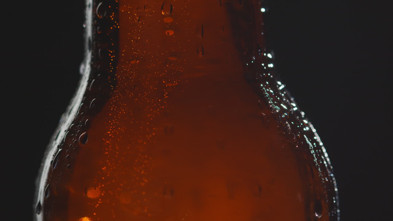 cerrar las gotas de condensación que corren hacia abajo botella giratoria de cerveza fría o bebida gaseosa 1