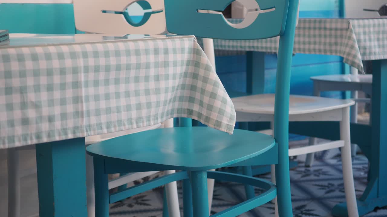 Interior with blue and white chairs and checkered tablecloths
