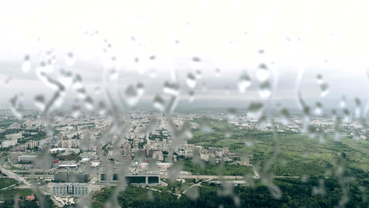 High Attitude Aerial Footage Of An City With Rain Drops In Front