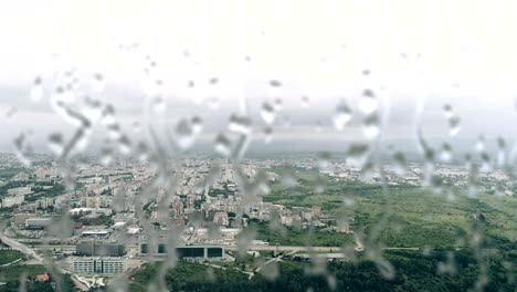 high attitude aerial footage of an city with rain drops in front