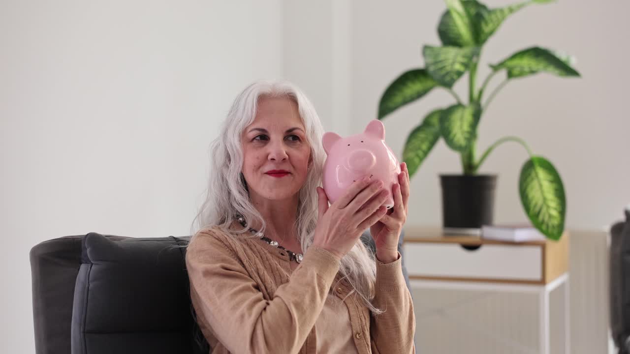 Senior Woman Holding a Pink Piggy Bank