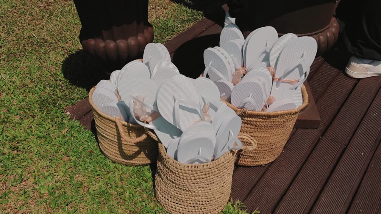 흰색 플립플롭으로 가득 찬 바구니가 야외 행사를 위해 준비되어 있어요