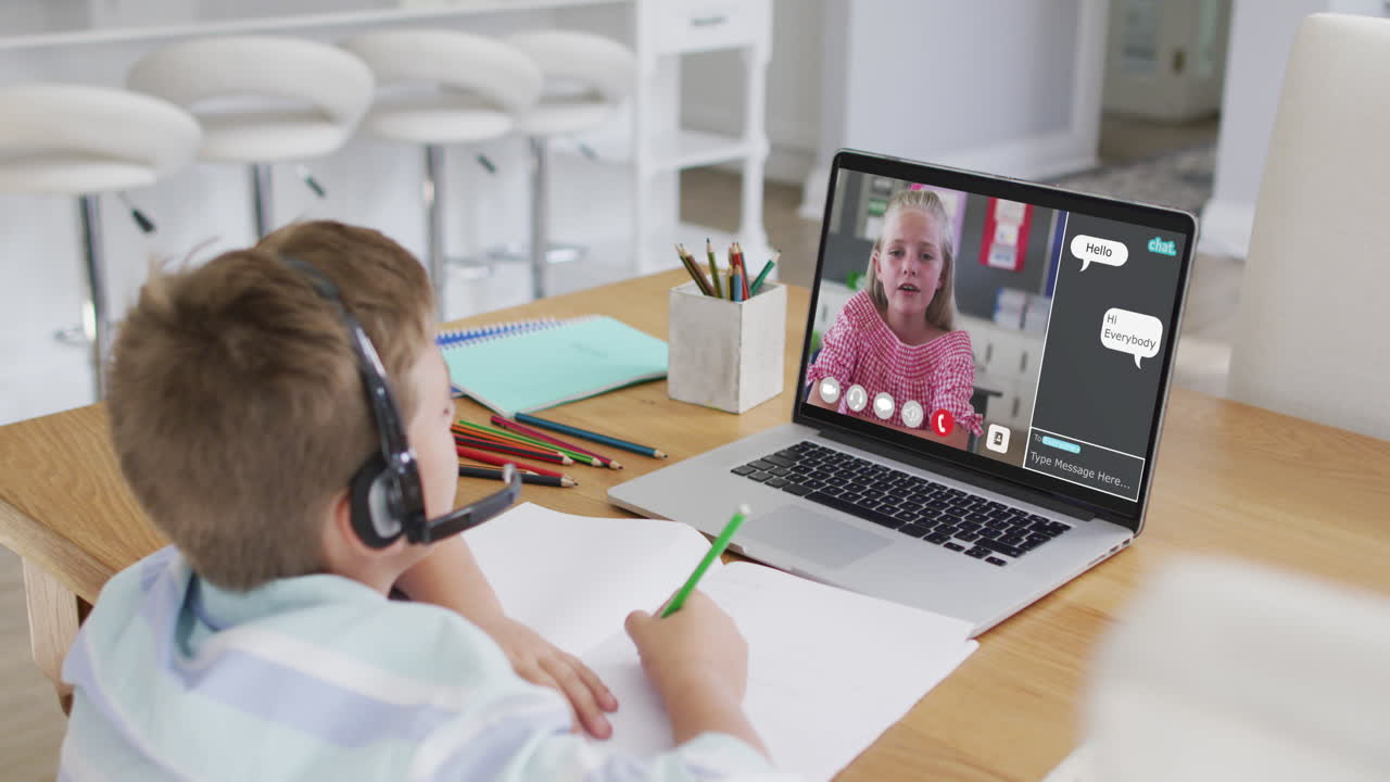 Schoolboy using laptop for online lesson at home, with his colleague and web chat on screen