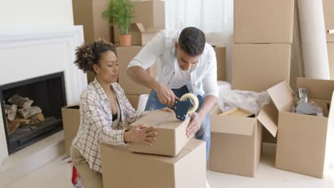 young couple packing boxes to move home