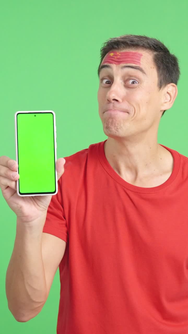 China supporter looking at his mobile smiling and showing it