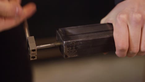 person using rotating lathe thread cutter at metal