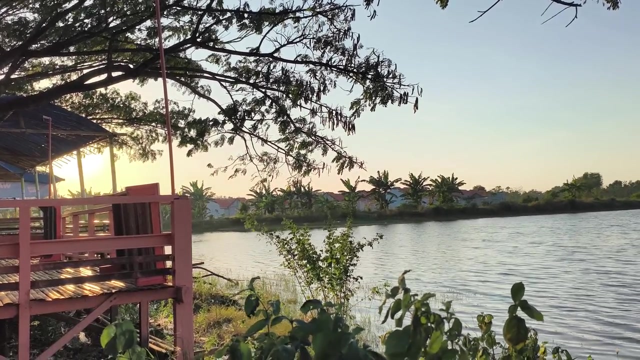 Gazebo in legno vicino a un lago calmo al tramonto