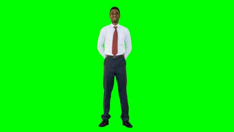 businessman standing and smiling against green background