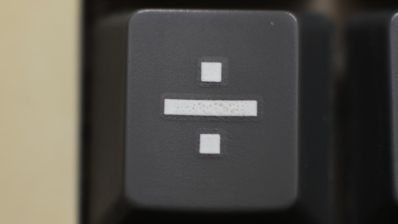 Macro close up of a division key being pressed for budgeting and fair splits