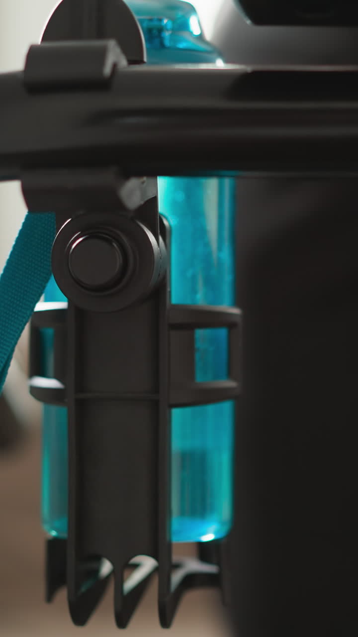 mujer corre en una cinta de correr con una botella de agua en el gimnasio de primer plano. mujer deportiva utiliza equipos de entrenamiento modernos para cuidar el cuerpo en casa en cámara lenta