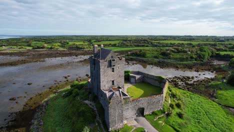 órbita aérea alrededor del viejo castillo de dunguaire dentro de un hermoso paisaje rural irlandés, día soleado