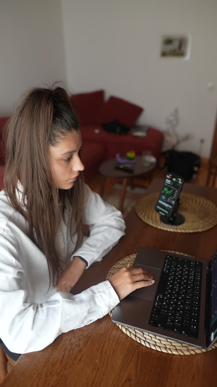 mujer joven trabajando en una computadora portátil en casa